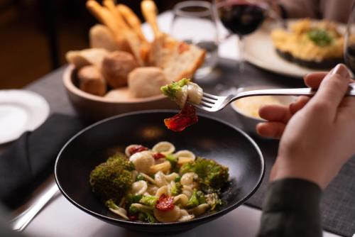 a person eating a bowl of food with broccoli at Huentala Hotel in Mendoza