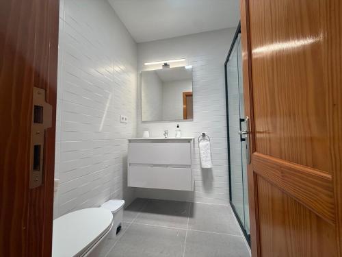 Un baño con inodoro, lavabo y espejo. en Las Brisas 38, 2 bedrooms and pool, en San Bartolomé