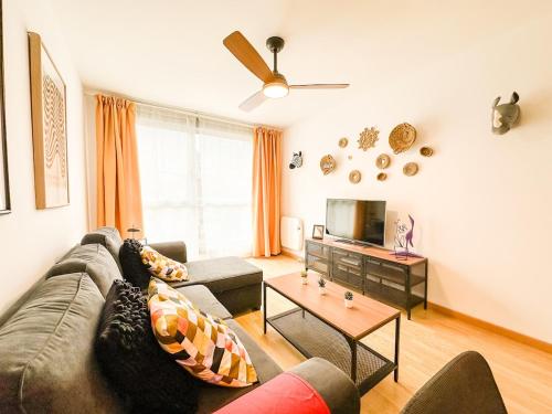 a living room with a couch and a tv at Apartamento Cee Centro - Playa by ALÔGA in Cee