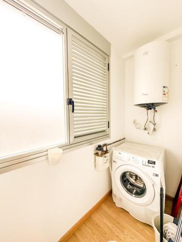 a laundry room with a washing machine and a window at Apartamento Cee Centro - Playa by ALÔGA in Cee