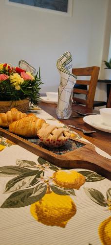 a wooden table with bread and flowers on it at Hope Horizon Villa Coonoor by LexStays in Coonoor