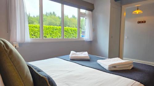 a bedroom with a bed with two towels on it at Lakeview Manor in Dunkeswell
