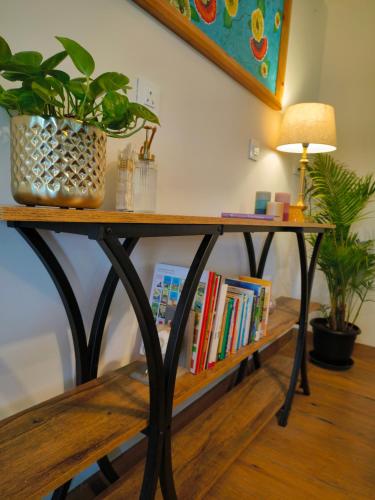 a table with a plant and books on it at Hope Horizon Villa Coonoor by LexStays in Coonoor