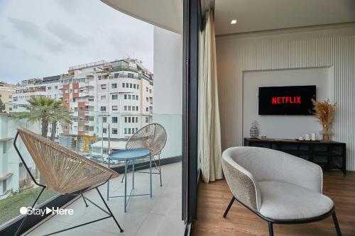 a balcony with chairs and a table and a view of a city at Stayhere Casablanca - Palmier - Executive Residence in Casablanca