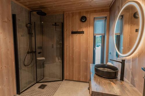 a bathroom with a shower and a sink and a tub at Tiur, stylish new cabin with hot tub in Nystølen
