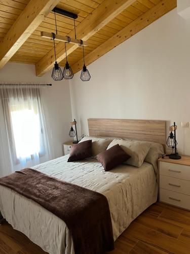 a bedroom with a large bed with two pillows at Apartamentos Rurales El Rincón de la Sierra 