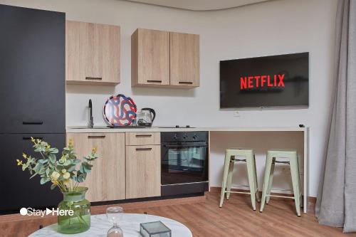 a kitchen with wooden cabinets and two bar stools at Stayhere Casablanca - Palmier - Executive Residence in Casablanca