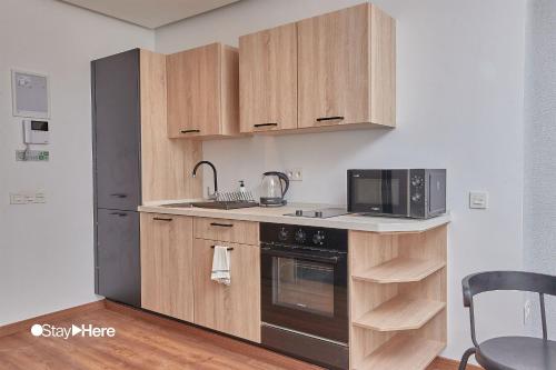 a kitchen with wooden cabinets and a black appliance at Stayhere Casablanca - Palmier - Executive Residence in Casablanca