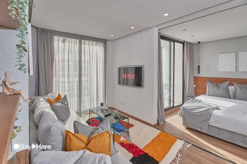 a bedroom with a couch and a bed and a tv at Stayhere Casablanca - Palmier - Executive Residence in Casablanca