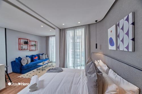 a bedroom with a bed and a blue couch at Stayhere Casablanca - Palmier - Executive Residence in Casablanca
