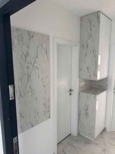 a room with white marble walls and a door at Apartman "Paolo" Istočno Sarajevo in Vranješ