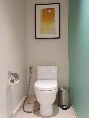 a bathroom with a toilet with a picture on the wall at Novotel Manila Residence Hotel by Jolly Luxe Suites at Acqua in Manila