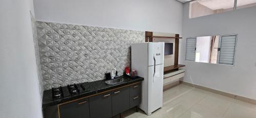 a kitchen with a refrigerator and a sink at 196 B · Loft B Hospede-se em Frente ao Parque ecológico in Indaiatuba