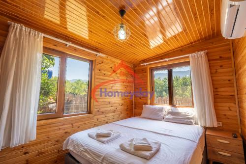 Un dormitorio con una cama en una cabaña de madera. en Cirali Camping, en Kemer