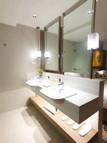 a bathroom with two sinks and a large mirror at Novotel Manila Residence Hotel by Jolly Luxe Suites at Acqua in Manila