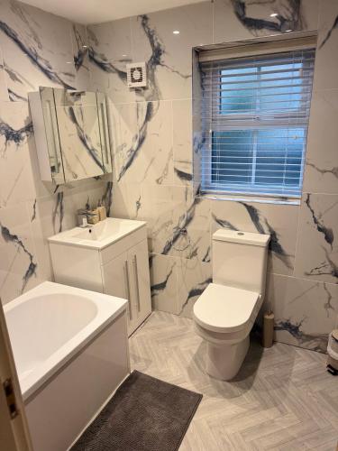 a bathroom with a toilet and a tub and a sink at 3 Bedroom House with free on site Parking next to the Canal in Keighley