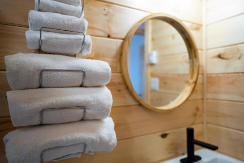 a stack of towels in a bathroom with a mirror at Beach Cabin 1 in Chéticamp