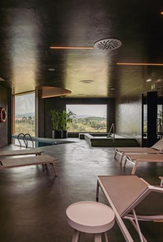 a room with tables and chairs and a pool at Haven Nature Hotel & Villas in Batalha