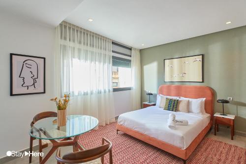 a bedroom with a bed and a glass table at Stayhere Casablanca - Gauthier 2 - Contemporary Residence in Casablanca