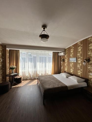 a bedroom with a large bed and a large window at Hotel Plazma in Lviv
