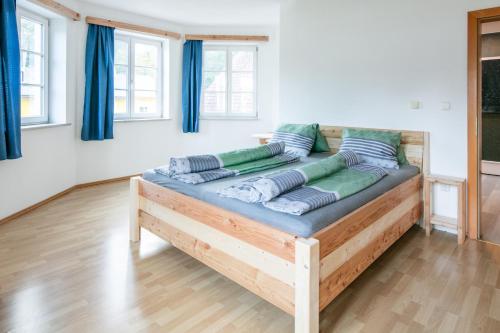 a bed in a room with blue curtains at Franzlhof Appartements in Stainz