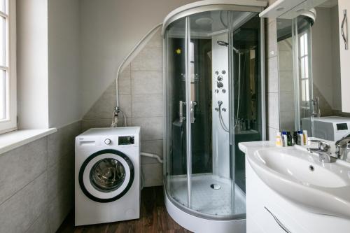 a bathroom with a washing machine and a sink at Franzlhof Appartements in Stainz