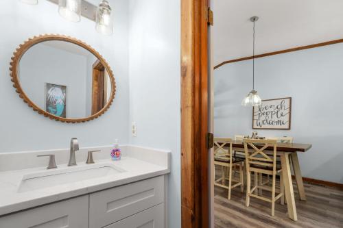 a bathroom with a sink and a mirror and a table at SDG2 Sea Glass Shack in Kitty Hawk