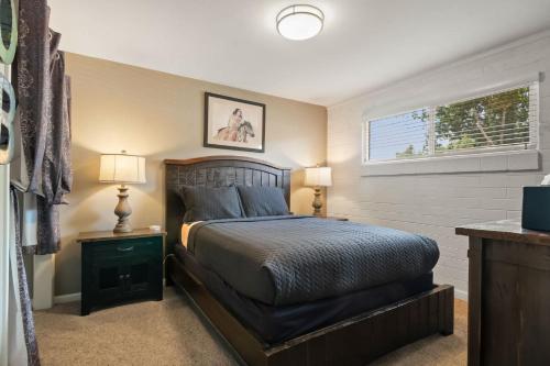 a bedroom with a bed and two lamps and a window at Downtown Cozy Home Base - Purple Sage 8 in Moab