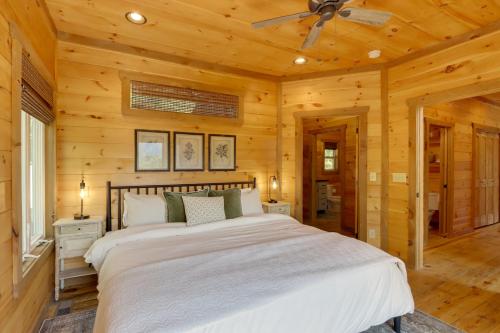 a bedroom with a large bed in a log cabin at Family Oasis with Game Room and 2 Decks in Blue Ridge! in Ballew Mill