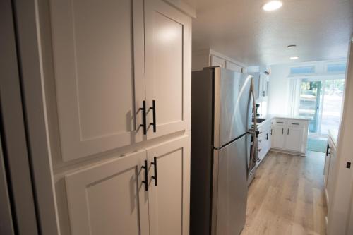 a kitchen with white cabinets and a refrigerator at Tiny House Village Yosemite-Blanca in Groveland