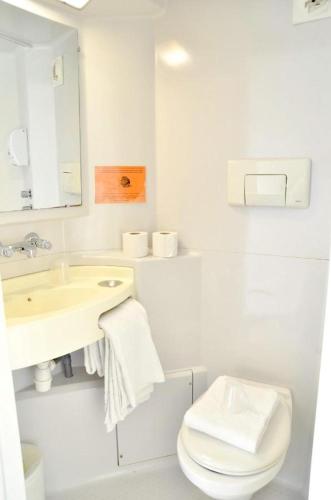 a white bathroom with a sink and a toilet at Mister Bed Saran in Saran