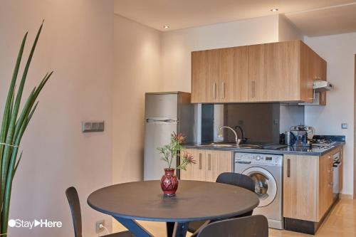 a kitchen with a table and a kitchen with a refrigerator at Stayhere Rabat - Hassan - Authentic Residence in Rabat