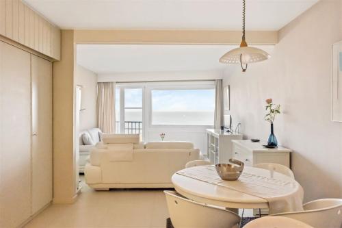 a living room with a couch and a table at Seaview cosy studio Costa Brava in Blankenberge