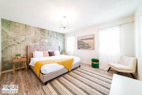 a bedroom with a bed and a chair at Spa Oasis Home - Hot Tub - King Bed - BBQ - Garage - Pets! in Edmonton