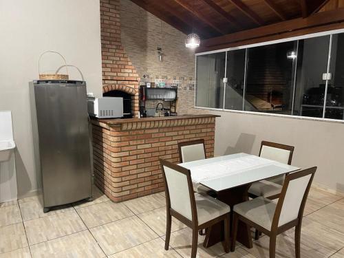 a kitchen with a table and chairs and a counter at casa Belo Horizonte · Casa 3 quartos parte superior individual com suite in Indaiatuba