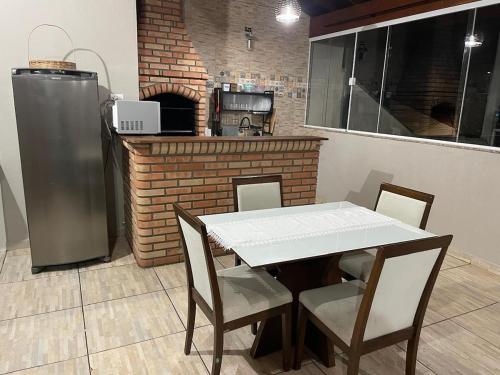 a kitchen with a table and chairs and a refrigerator at casa Belo Horizonte · Casa 3 quartos parte superior individual com suite in Indaiatuba