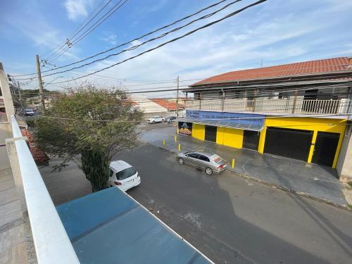 a street with cars parked in front of a yellow building at casa Belo Horizonte · Casa 3 quartos parte superior individual com suite in Indaiatuba