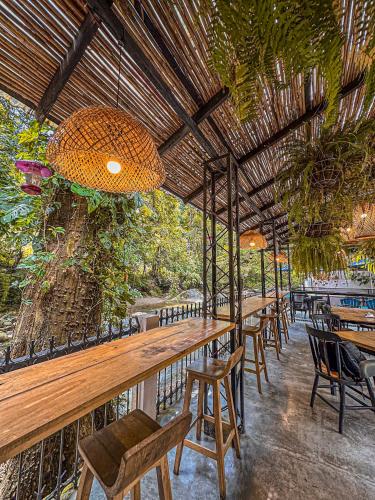 a restaurant with wooden tables and chairs and a tree at Hotel Casa de Hadas in Minca