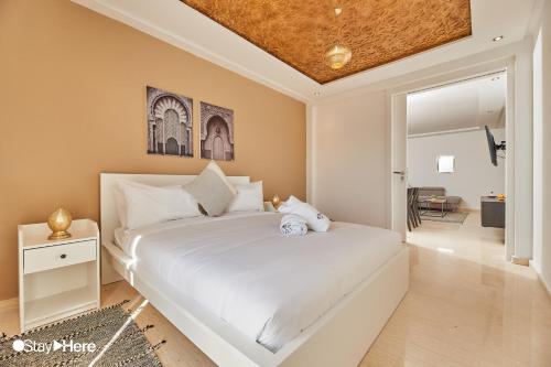 a bedroom with a white bed with a teddy bear on it at Stayhere Rabat - Hassan - Authentic Residence in Rabat