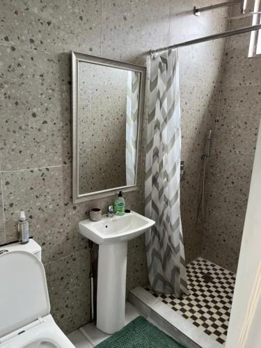 a bathroom with a sink and a shower with a mirror at Ocean Village in Amanzimtoti