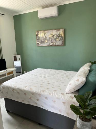 a bedroom with a bed and a painting on the wall at Ocean Village in Amanzimtoti
