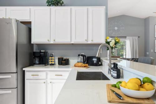 a kitchen with white cabinets and a bowl of fruit at The Sunny - Theme Parks , Heated Pool , Grill in Davenport