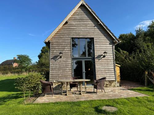 a small house with a table and chairs in the yard at Le Cottage enchanteur du Renouard avec sa Vue panoramique in Le Renouard
