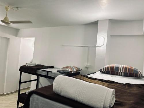 a room with two beds and a table in it at White Portico in Thekkady