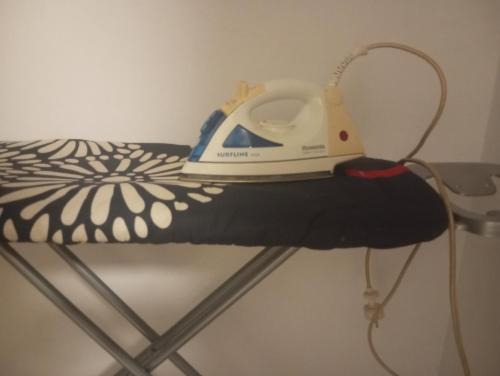 a iron is sitting on top of a bed at Room Flower Near Airport in Ariana