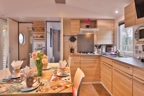 a kitchen with a table with flowers on it at Plaisirs d'Alsace - Munster - Colmar - Route du vin in Munster