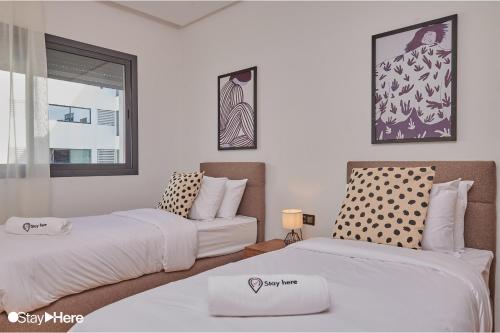 a bedroom with two beds and a window at Stayhere Rabat - Hay Riad - Sophisticated Residence in Rabat