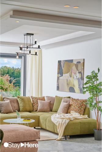 a living room with a green couch in front of a window at Stayhere Rabat - Hay Riad - Sophisticated Residence in Rabat