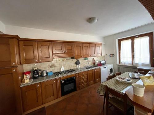 a kitchen with wooden cabinets and a table in it at Casa Vacanza Patrizia in Bastia Umbra