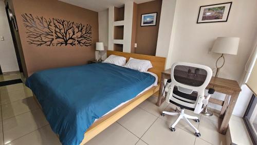 a bedroom with a bed and a desk and a chair at S01 SUITE KING SIZE Premium Frente al TEC CEM con Cocineta WiFi Balcón Parking Terraza in Mexico City